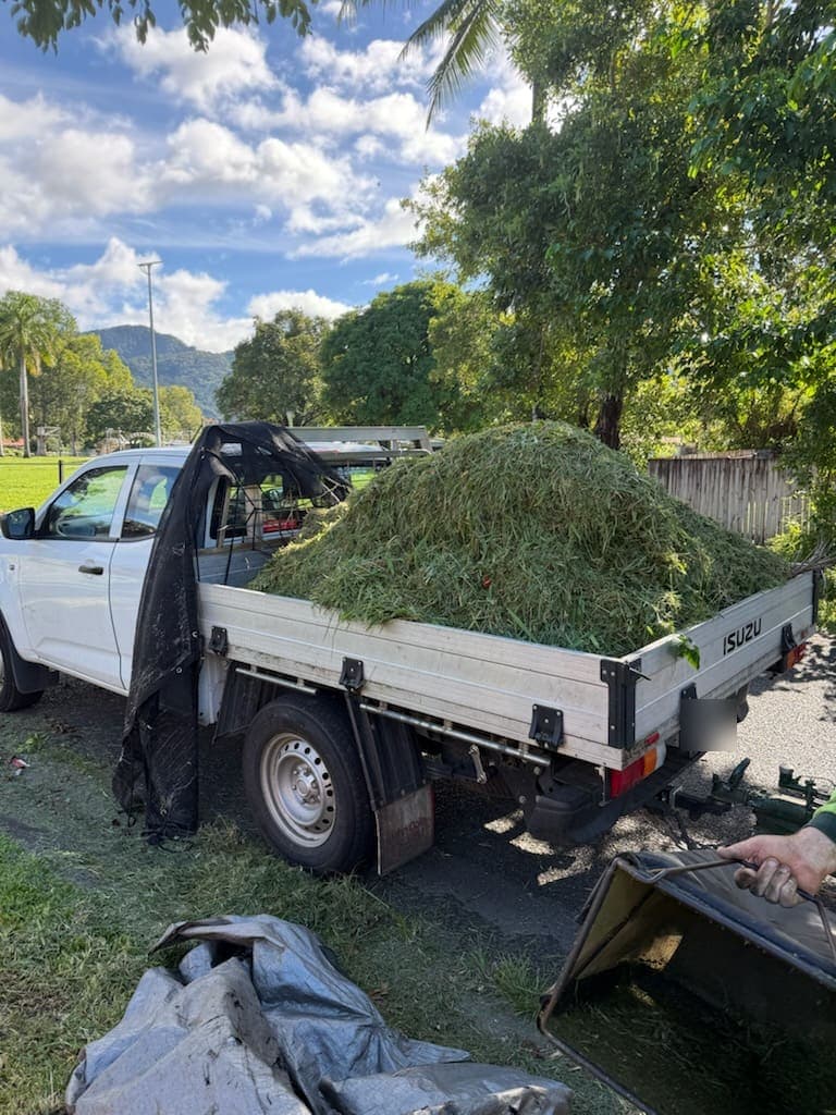 Work tipper loaded with grass clippings from a mowing round, ranges behind