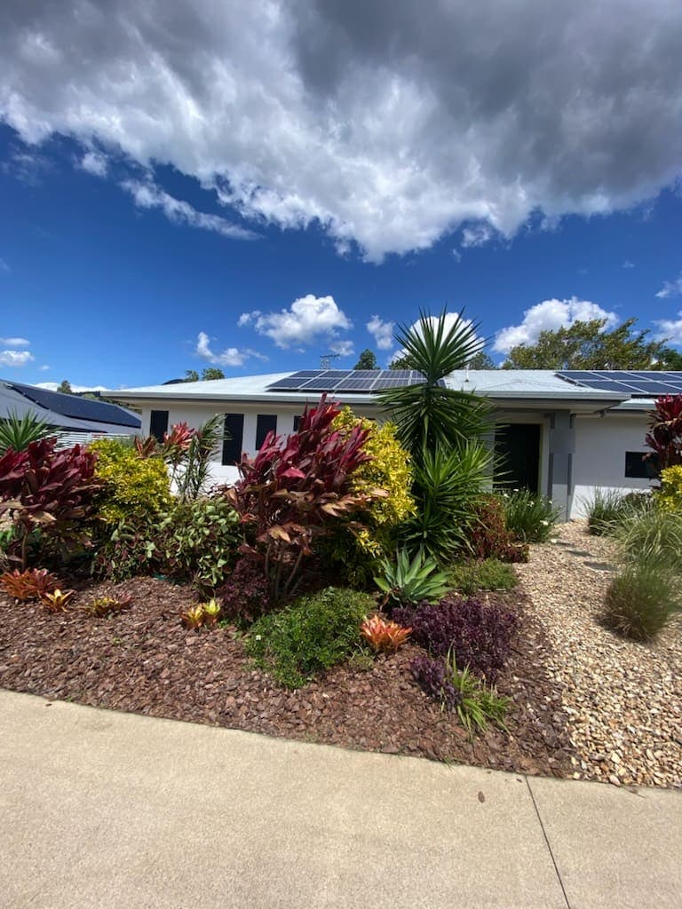 Established tropical planting holding colour in a freshly mulched front bed
