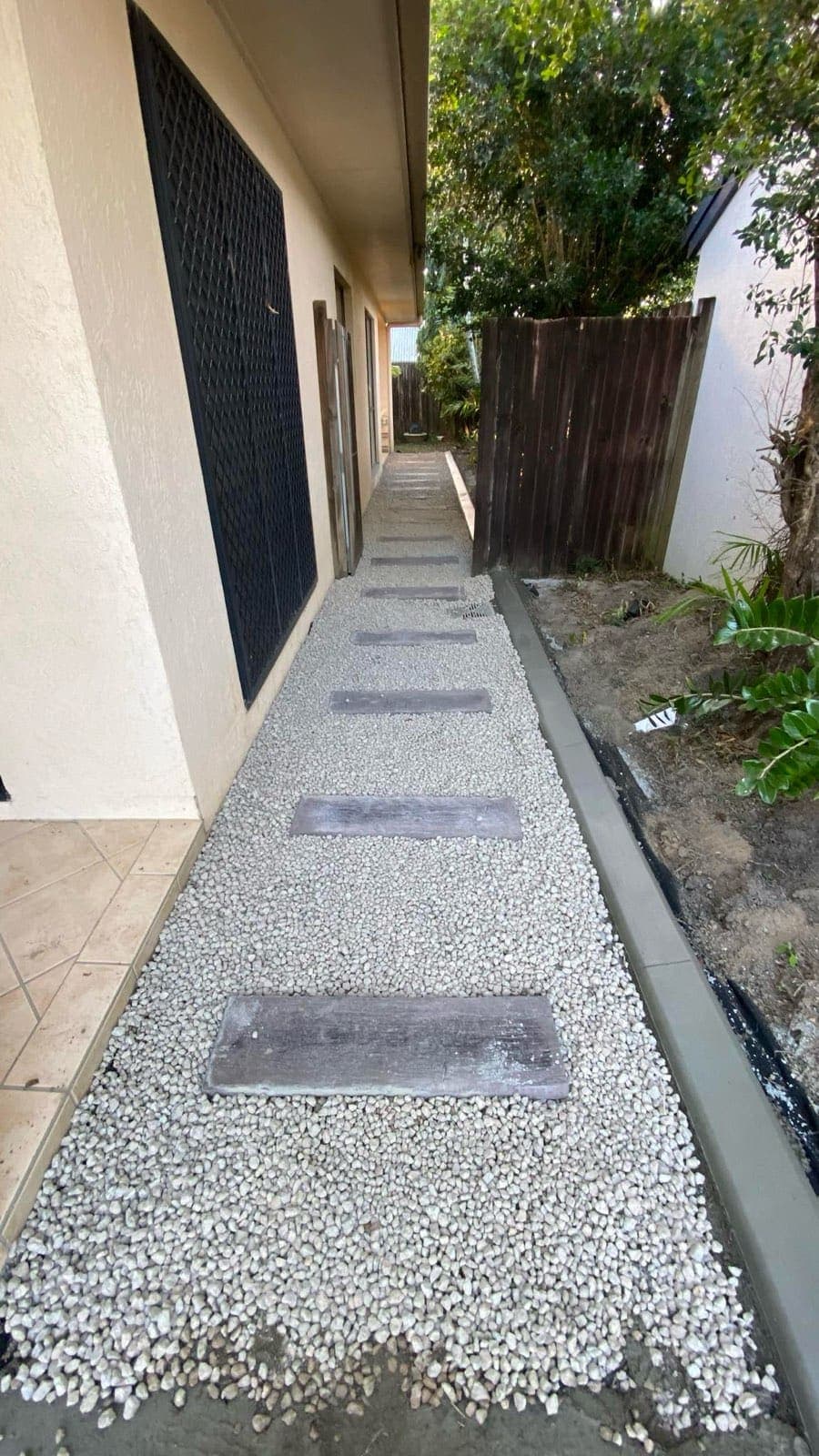 Pebble path and stepping stones with a concrete edge at a Cairns property