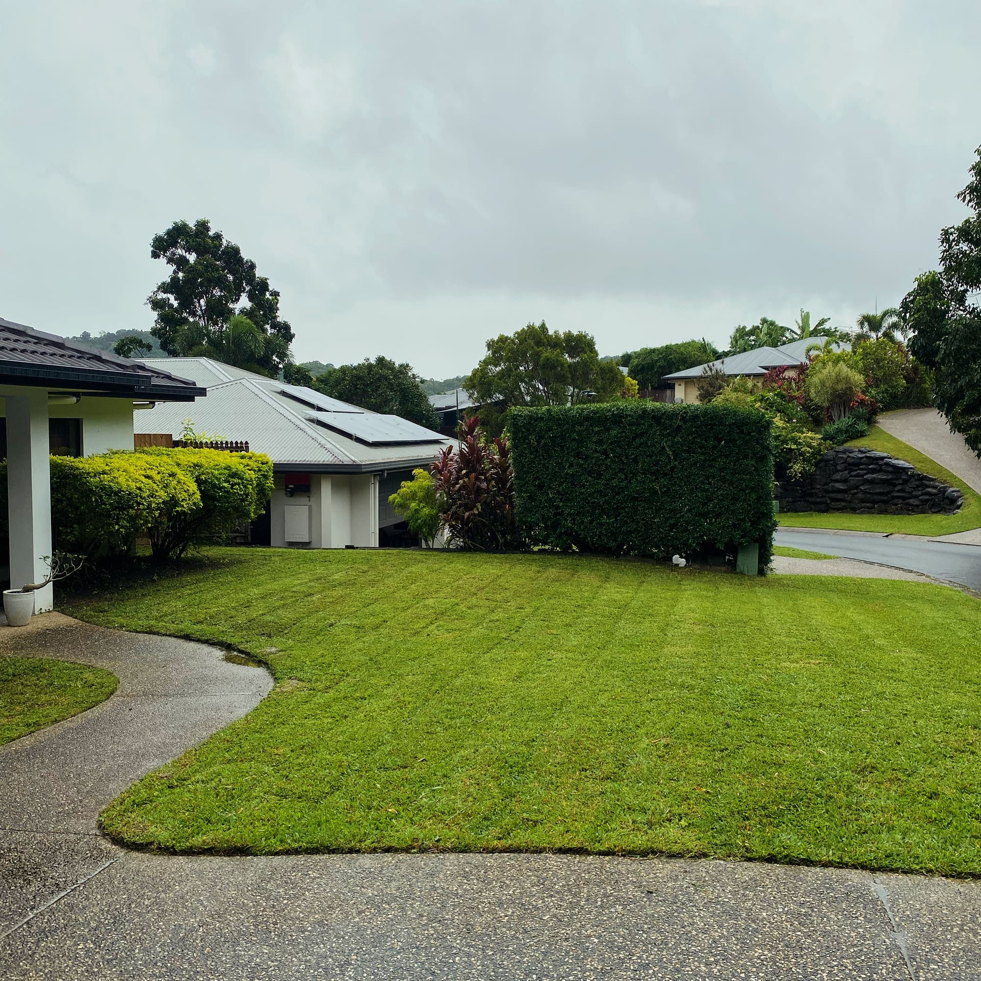 Front lawn mown in stripes with a clean driveway edge at a Cairns home